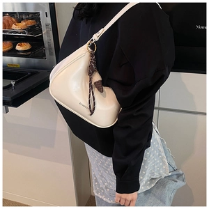 Détail du sac hobo blanc crème avec breloque crème glacée et bandoulière tressée chic