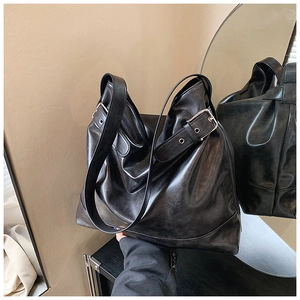 Detail of black large capacity hobo bag featuring smooth faux leather and silver buckles
