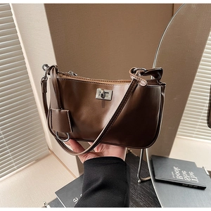 Detail of retro brown faux leather shoulder bag featuring a silver metal twist lock