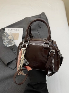 Chocolate brown faux leather pillow bag with white contrast stitching and charm