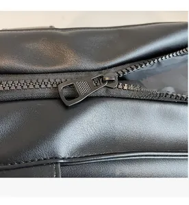 Vue macro de la fermeture éclair en métal noir et détails du cuir sur le sac cabas
