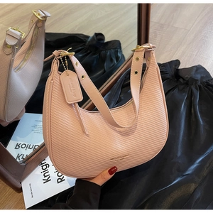 Detail view of light pink hobo bag with woven texture and adjustable shoulder strap