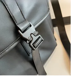 Gros plan de la boucle métallique noire mate sur le sac cabas en cuir grainé noir