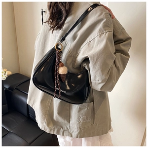 Détail du sac croissant noir brillant avec un pendentif créatif en cornet de glace