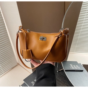 Detailed view of caramel leather shoulder bag with silver turn-lock and matte finish
