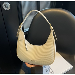 Close-up of beige woven leather hobo bag with gold hardware and brand tag detail