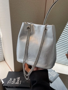 Silver metallic bucket bag with chain strap and pleated faux leather texture