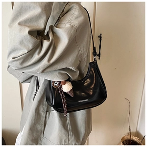 Sac sous le bras croissant noir brillant avec breloque glace porté par mannequin
