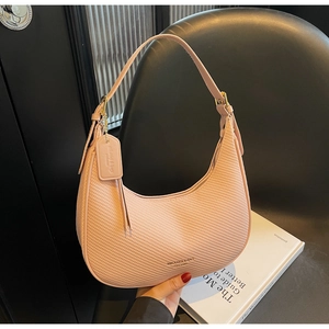 Detail of light pink crescent bag showing woven texture and adjustable strap buckles