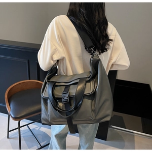 Détail du sac cabas gris avec boucle noire et large bandoulière réglable pratique