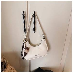 Détail du sac demi-lune crème en cuir lisse avec pendentif décoratif en forme de glace