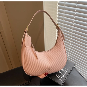 Close-up of pink crescent underarm bag with woven textured leather and gold hardware