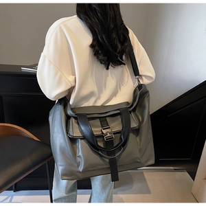 Détail du grand sac cabas gris avec boucle industrielle noire et bandoulière large