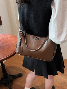Minimalist vintage brown shoulder bag with silver turn-lock and metallic circular charm