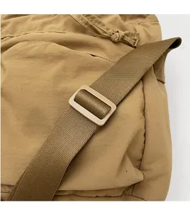 Dettaglio della tracolla regolabile in nylon sulla borsa a secchiello casual kaki da donna