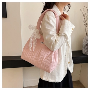 Dettaglio della borsa rosa arricciata con fiocco di pizzo e patch LOVE