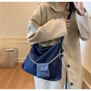 Detail of dark blue denim hobo bag with silver chain and matching mini pouch attachment