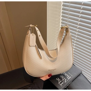 Detailed view of woven dumpling bag with adjustable leather strap and gold hardware