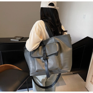 Détail du grand sac cabas gris foncé avec poche utilitaire et sangle tissée élégante