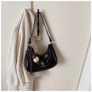 Détail du sac croissant en cuir verni noir avec pendentif glace suspendu au crochet