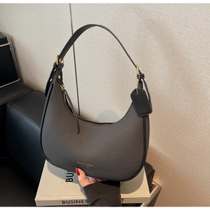 Detail of grey textured hobo bag featuring gold hardware and leather trim details