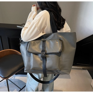 Détail du sac cabas gris foncé avec texture mate, poche à rabat et boucle tactique