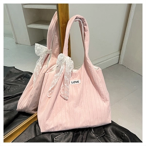 Dettaglio della borsa tote rosa soffice con fiocco in pizzo bianco e scritta LOVE