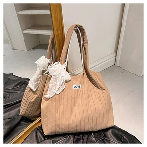 Dettaglio borsa tote marrone trapuntata con texture a pieghe e fiocco in pizzo