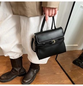 Détail du sac bandoulière en cuir noir avec boucle de ceinture sur fond de style de vie