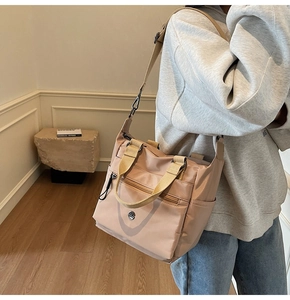 Detail of light brown nylon tote bag with adjustable strap and multi-pocket design
