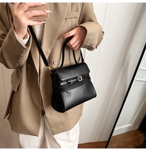 Détail du sac à main carré noir avec boucle de ceinture porté par un mannequin