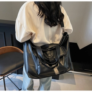 Détail d'un grand sac cabas noir en similicuir porté par un mannequin, vue de l'arrière