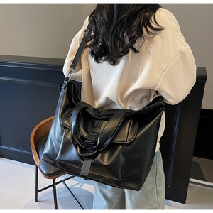 Détail d'un grand sac fourre-tout noir vintage avec bandoulière large sur mannequin