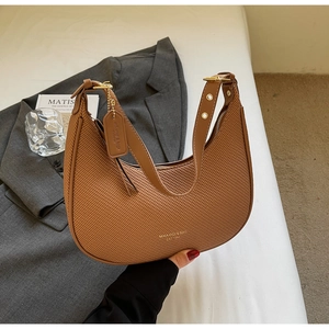 Close-up of brown woven dumpling bag with gold hardware buckle and leather strap