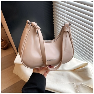 Détail du sac demi-lune abricot en similicuir lisse avec logo de marque gravé sur le sac