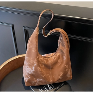 Close-up of brown marble-pattern hobo bag with satin finish and golden hardware detail