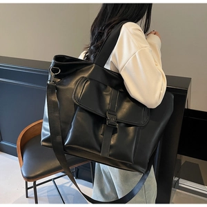 Détail d'un grand sac fourre-tout noir mat en cuir PU avec poche avant à boucle rabattable