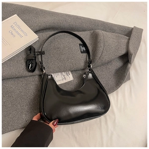 Détail d'un sac demi-lune en cuir verni brillant noir avec bandoulières interchangeables