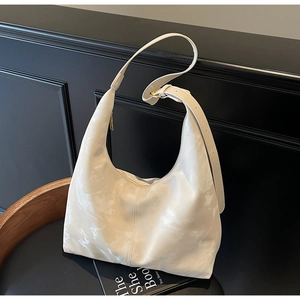 Detail of cream shoulder bag with marble pattern, adjustable strap and gold hardware