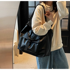 Gros plan d'un sac cabas noir en cuir avec poche à rabat avant et finition mate chic