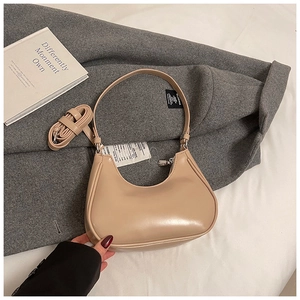 Gros plan d'un sac hobo beige en cuir lisse avec une bandoulière amovible réglable