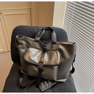 Détail du grand sac cabas gris-vert avec poche avant bouclée et bandoulière robuste