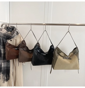 Detail of vintage leather tote bags in four classic colors on a metal display rack