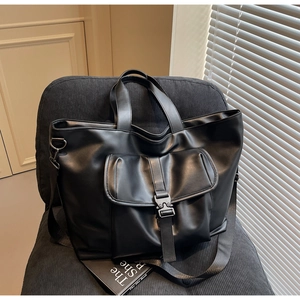 Vue détaillée du sac cabas noir avec poche à boucle et large bandoulière amovible