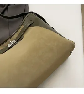 Detail of the two-tone leather tote with metal turn-lock closure and suede texture