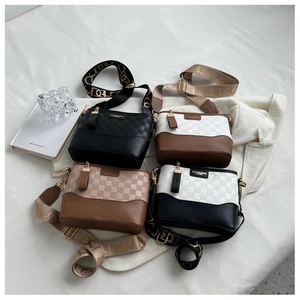 Detail shot of checkered crossbody bags with branded wide straps and metal hardware