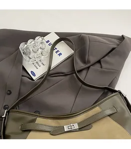 Detail of olive green and beige leather shoulder bag with silver metallic twist lock
