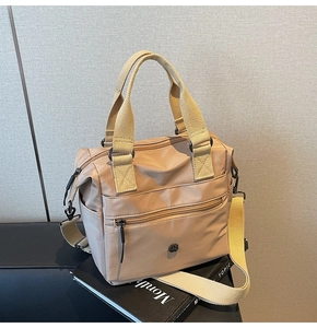 Detail of khaki nylon tote bag with multiple pockets and adjustable shoulder strap