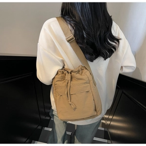 Dettaglio della borsa a secchiello in nylon kaki con coulisse e tracolla regolabile