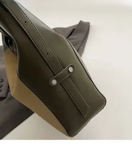 Detail view of khaki and olive leather tote bag with silver rivets and stitching